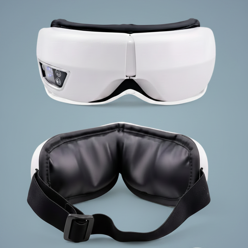 White and black electric eye massager shown from the front and side, with a close-up inset of the black textured fabric on a muted blue-gray background.